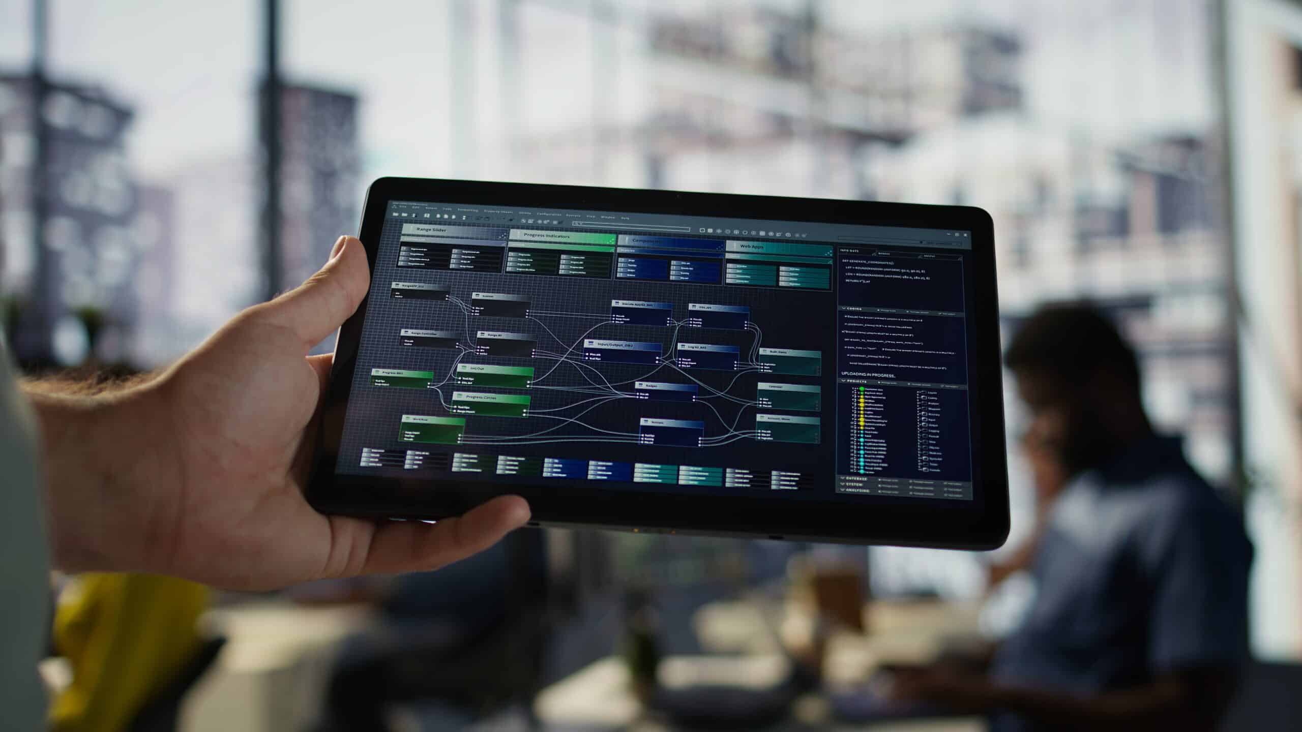 Softwareingenieur hält Tablet mit Finanzdaten Dashboard